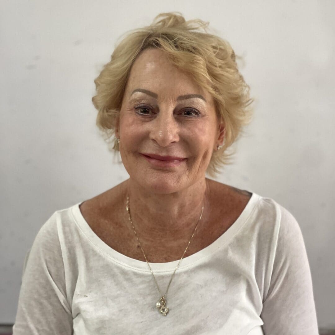 A woman with blonde hair wearing white shirt.