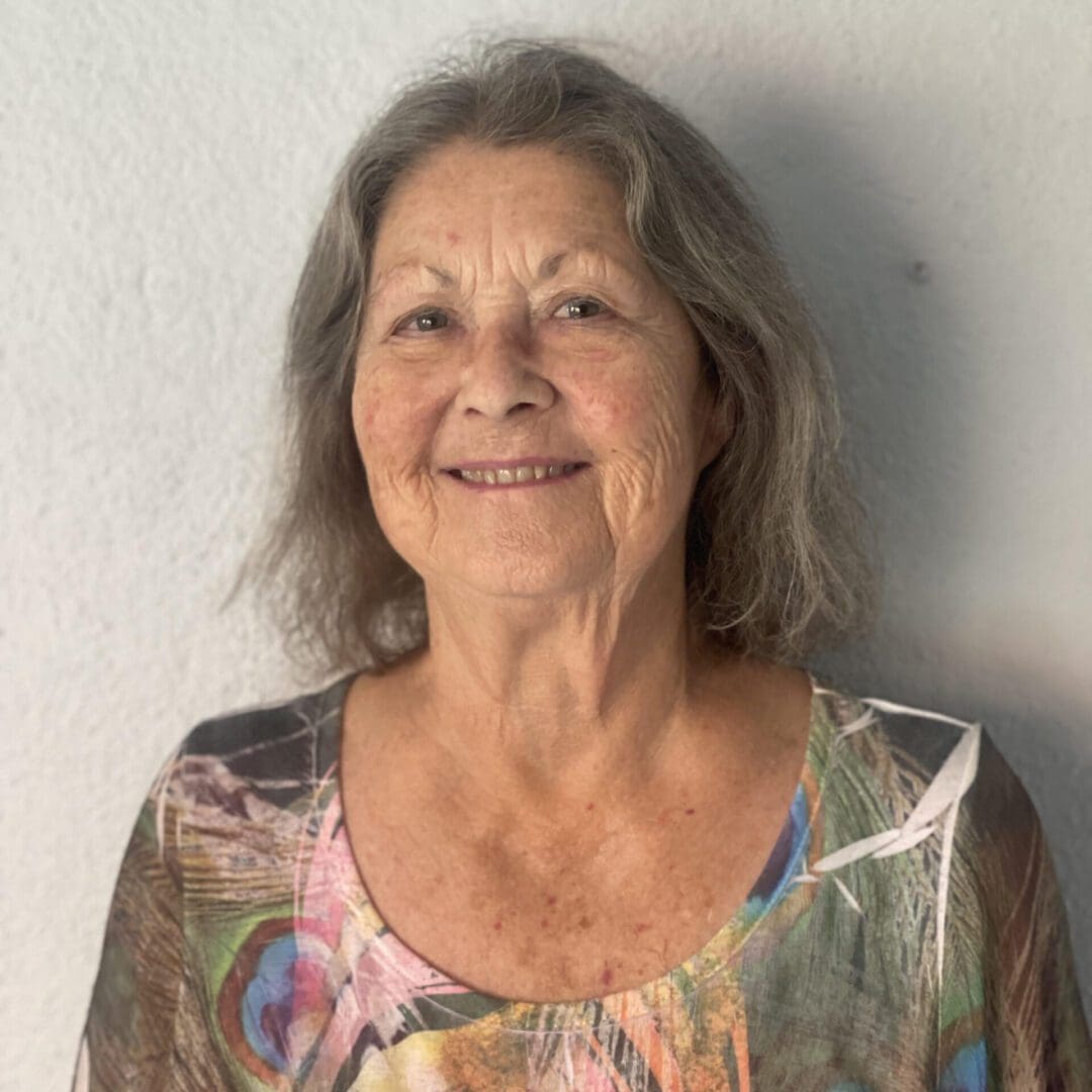 A woman with long hair and a colorful shirt.