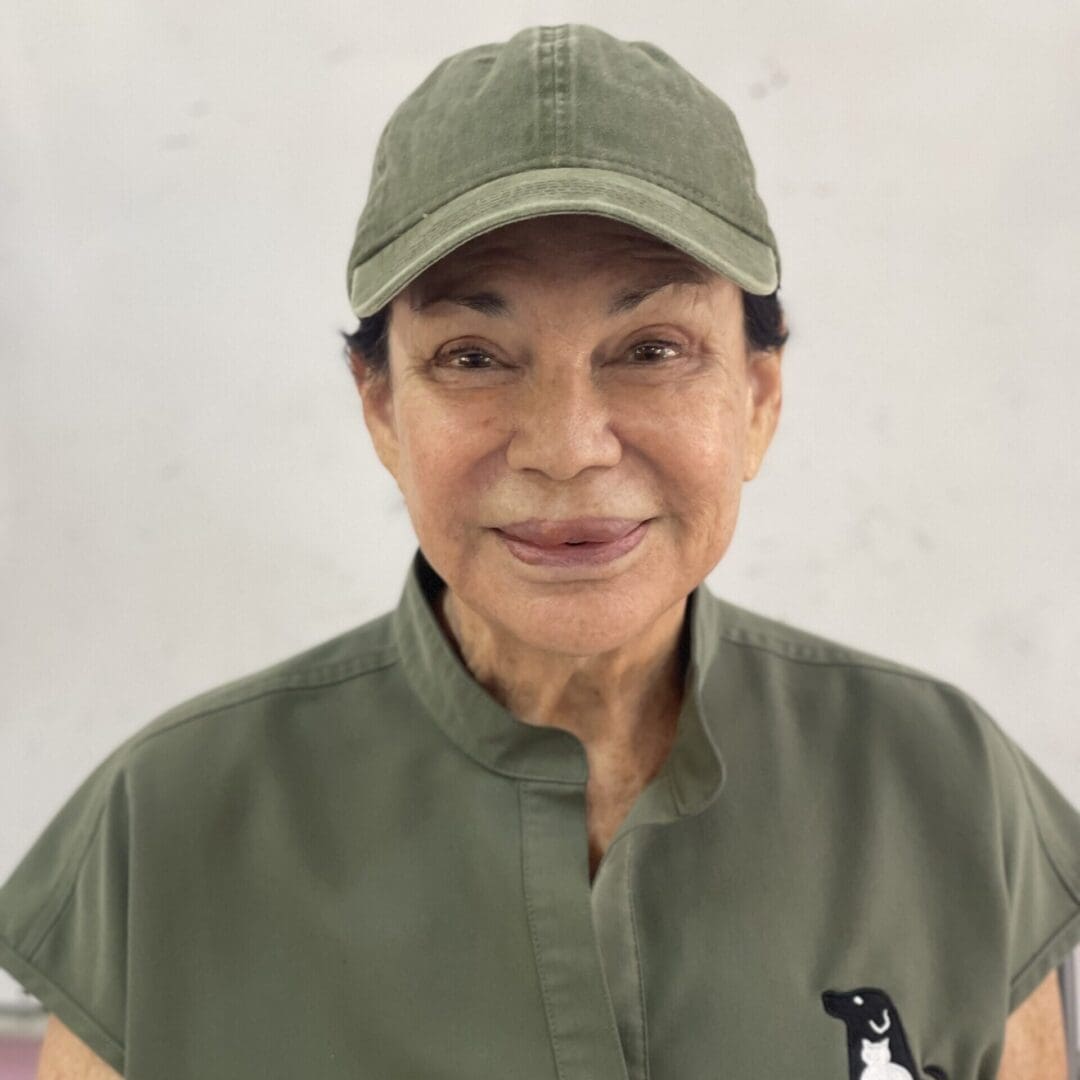 A woman wearing a green cap and shirt.