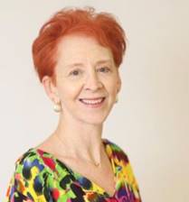 A woman with red hair and a colorful shirt.